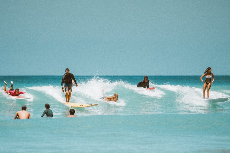 People Surfing on Sea